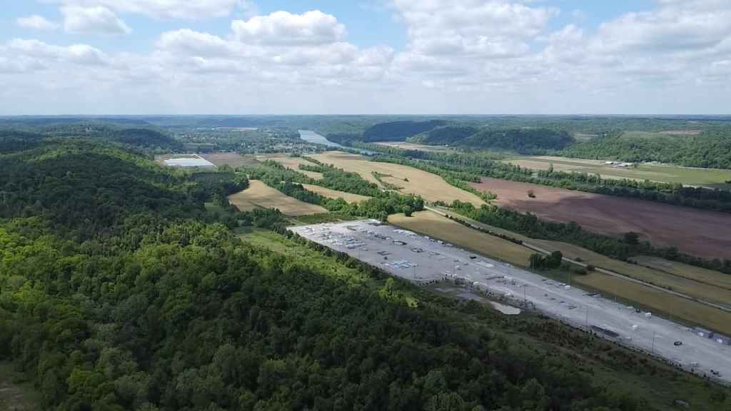 Aerial view of industrial development near farmland and wooded hills in Putnam County